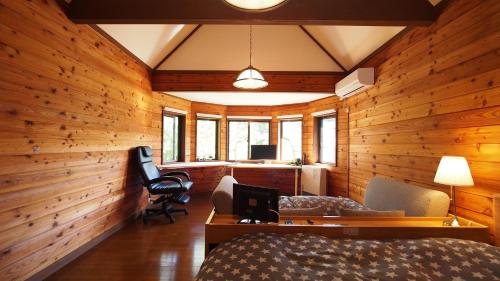 a bedroom with wooden walls and a bed and a desk at お湯掛け流し『草津温泉湯畑』徒歩圏内※温泉街を大勢で遊びたい & 癒されたい in Kusatsu