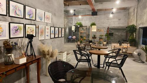 restauracja ze stołami, krzesłami i obrazami na ścianie w obiekcie MostPopular!!! Hay Cafe TranquilFields - OnlyYou with Hay, Rentable For Event w mieście Sekinchan