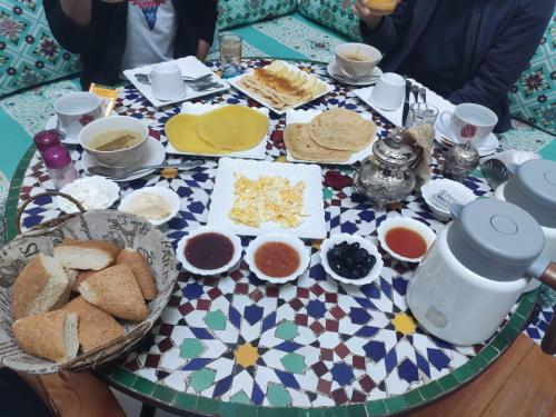 une table avec une assiette de pain et d'autres denrées alimentaires dans l'établissement Riad Fes Colors & Spa, à Fès