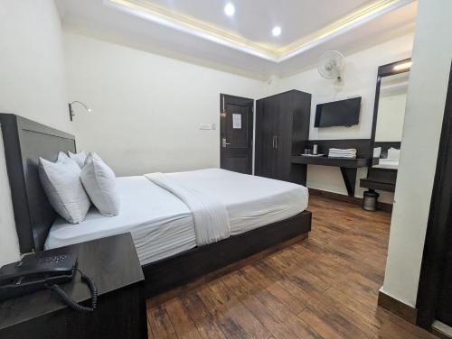 a hotel room with a bed and a television at Summer Capital BnB in Shimla