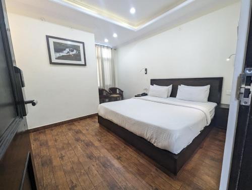 a bedroom with a large white bed in a room at Summer Capital BnB in Shimla