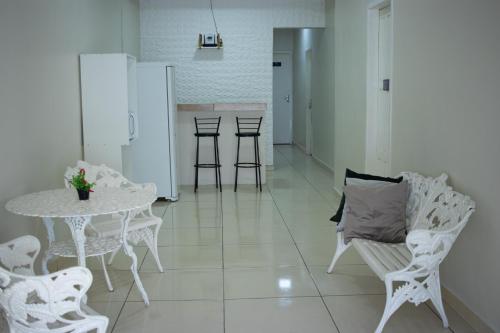 une salle à manger avec une table et des chaises ainsi qu'une table et des chaises blanches dans l'établissement Hospedaria Valdice Damasceno Centro Histórico, à Piranhas