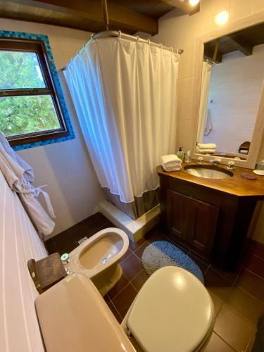 a bathroom with a toilet and a sink and a tub at Otto House in San Carlos de Bariloche