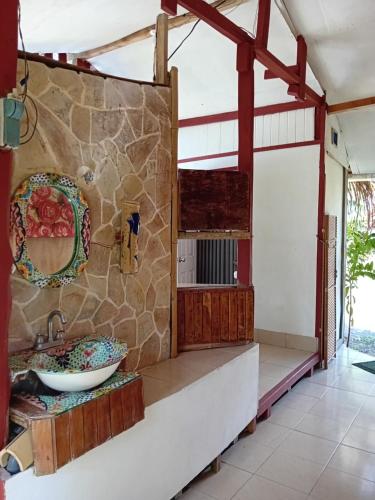 a bathroom with a sink and a stone wall at Lodge El Barco in Esterillos