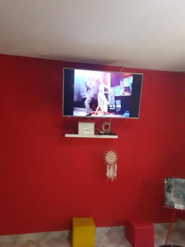 een woonkamer met een rode muur en een flatscreen-tv bij Casa fermin carrizo in San Isidro