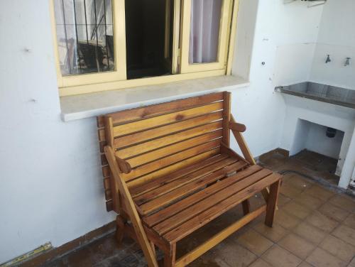 a wooden bench in a room with a window at Casa Argenta in Córdoba