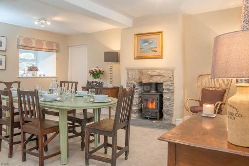 a dining room with a table and a fireplace at Cwmain in Cerrigydrudion