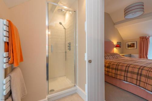 a bathroom with a shower next to a bed at Cwmain in Cerrigydrudion