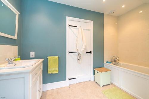 a bathroom with a sink and a tub and a shower at Cwmain in Cerrigydrudion