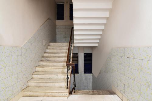 una escalera en una casa con azulejos azules y blancos en OYO Flagship Hotel Sai Krishna, en Khandagiri