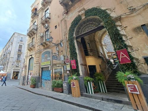 a building with an arch on the side of a street at I Vespri in Catania