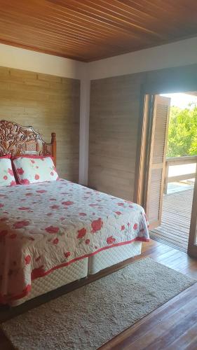 a bedroom with a bed and a sliding glass door at Rancho 3 Guri in Osório