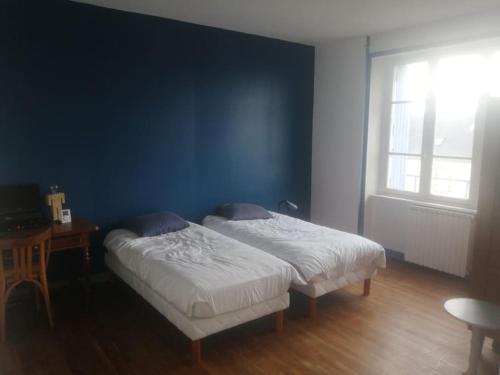 Ce lit se trouve dans une chambre dotée d'un mur bleu. dans l'établissement Grande maison dans un village côtier du Finistère, à Guissény