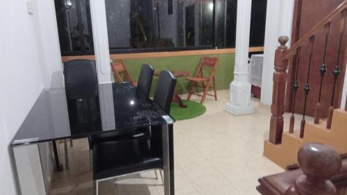 a living room with a table and chairs in a room at Kandy River Garden in Kandy