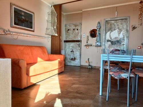 ein Wohnzimmer mit einem orangenen Sofa und einem Tisch in der Unterkunft Casa Vacanze Marina di Pisa Catola in Marina di Pisa