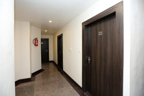 a hallway with a wooden door in a building at Hotel Relax in Gwalior