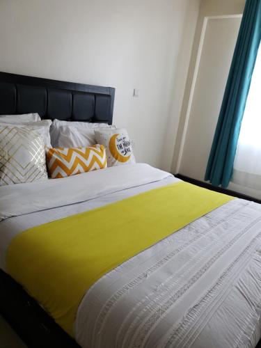 een bed met een gele deken erop bij Shyrah Havana in Nairobi