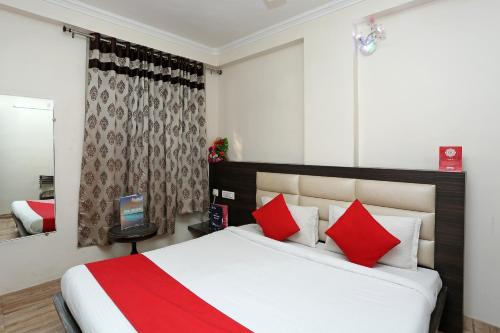 a bedroom with a large bed with red pillows at Hotel O Relax in Gwalior