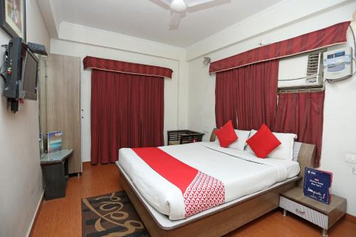 a bedroom with a large bed with red pillows at Hotel O Relax in Gwalior