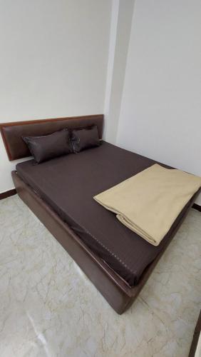 ウッジャインにあるHOTEL PRAKASH PALACEの茶色のベッドフレームが備わる客室のベッド1台分です。