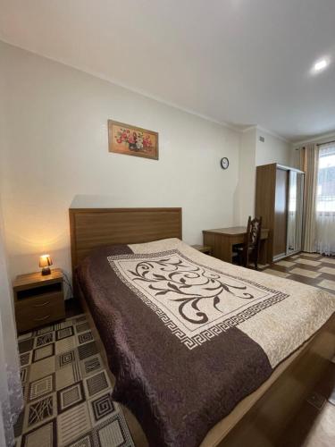ein Schlafzimmer mit einem großen Bett und einem Schreibtisch in der Unterkunft Оранта in Schidnyzja