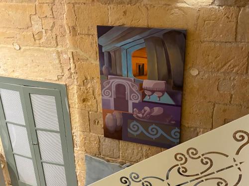 a painting hanging on a wall next to a door at Casa Cara in Birgu
