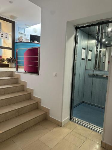 a hallway with stairs and a glass door in a building at Vila Trandafirul si Liliacul in Căciulata