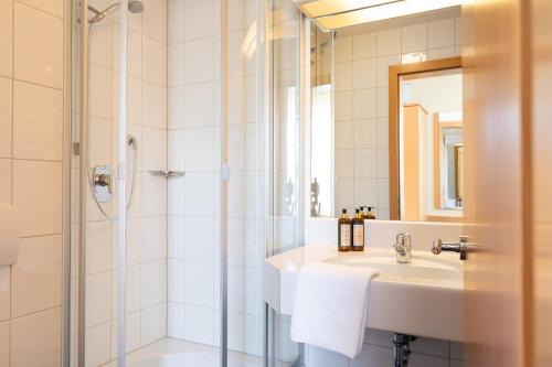 y baño con lavabo y ducha. en Allershausen Apartment Huberhof, en Allershausen