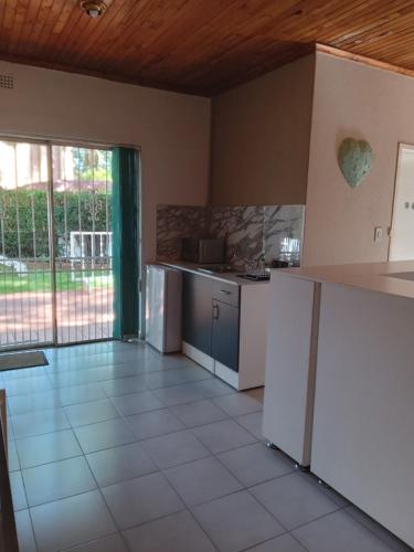 a kitchen with white appliances and a large window at "O Sole Mio" Self catering studio apartment in Bedfordview in Bedfordview