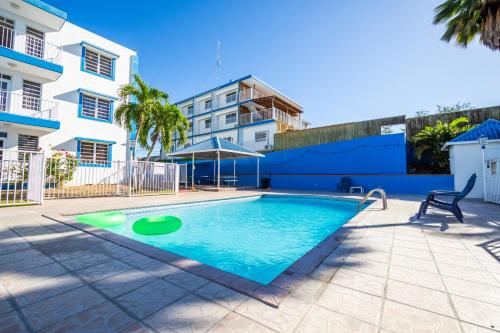 a swimming pool in front of a building at West Coast Inn's in Boqueron