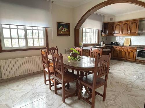 une cuisine avec une table et des chaises dans une pièce dans l'établissement Acogedora casa cerca de Marín, à Pontevedra
