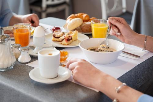 a group of people sitting at a table eating breakfast at Hotel Du Lac in Locarno