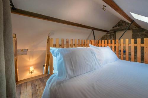 a bedroom with a large bed with white pillows at Ty-Gwair-Byrdir in Dyffryn