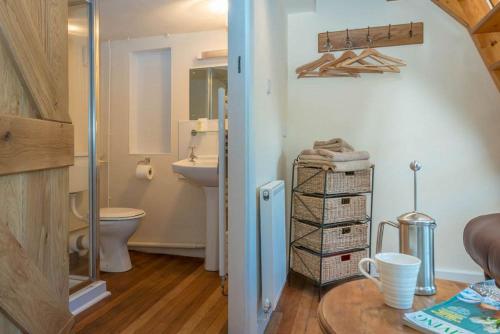 a bathroom with a sink and a toilet and a table at Ty-Gwair-Byrdir in Dyffryn