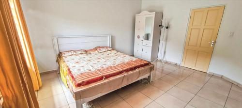 een slaapkamer met een bed in een kamer met een deur bij Kapowlito Real Estate Casa #2 Mon Plaisirweg in Paramaribo