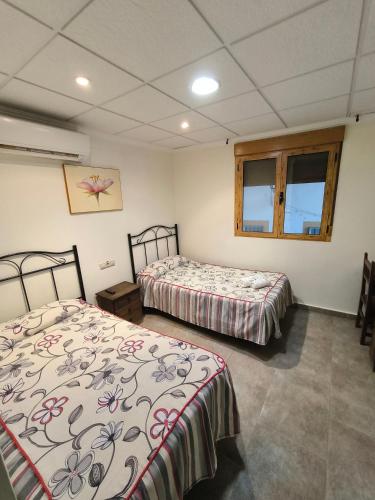 a room with two beds and a window at Ca' La Conchin in Cortez de Pallas