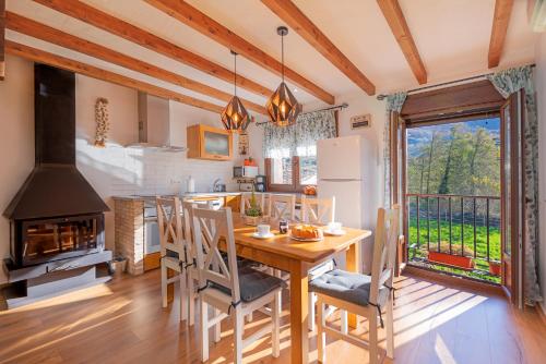a kitchen and dining room with a table and a fireplace at Casa Rural La Chopera del Jerte in Jerte