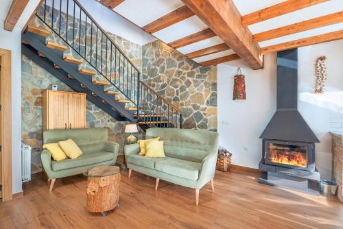 a living room with two chairs and a fireplace at Casa Rural La Chopera del Jerte in Jerte
