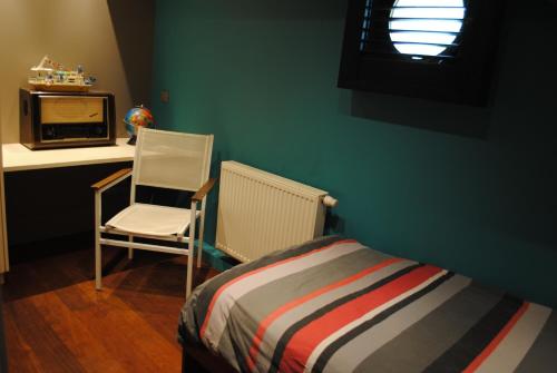 a bedroom with a bed and a chair and a microwave at Boat & Breakfast Bellevue in Ghent