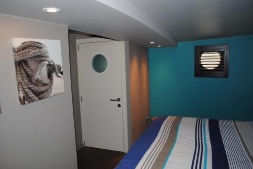 1 dormitorio con cama y pared azul en Boat & Breakfast Bellevue en Gante