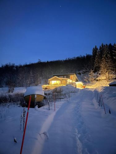 a house in the snow at night at Paradis med mange muligheter! in Nordmannvik