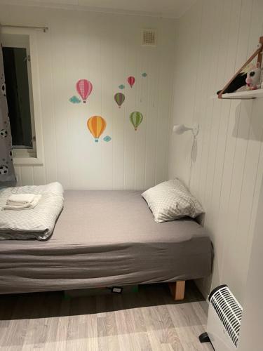 Una cama en una habitación con una pared con corazones. en Paradis med mange muligheter! 