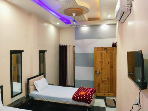 a room with a bed and a tv and a tv at Mishra Guesthouse in Varanasi
