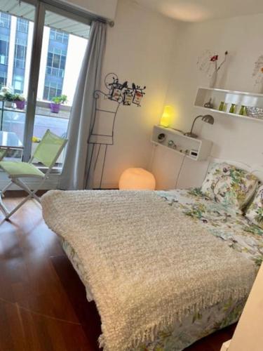 um quarto com uma cama, uma mesa e uma janela em La Vie en Rose-Montparnasse em Paris