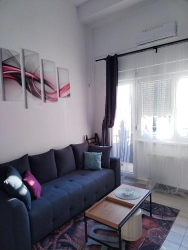 a living room with a blue couch and a table at Apartman Štimac in Petrovaradin