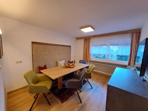 uma sala de jantar com uma mesa de madeira e cadeiras em Haus Tirol Appartements em Ried im Oberinntal