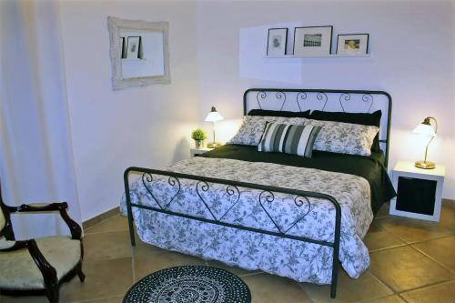 a bedroom with a large bed and a chair at Villa Paradiso in Scopello