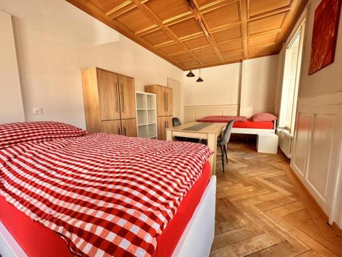 a bedroom with a red and white bed and a desk at Revier Kanzlei im Hazzo in Hätzingen