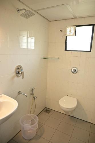 a bathroom with a toilet and a sink at Geetham Villas in Palakkad