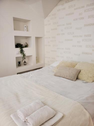Una cama blanca con dos toallas encima. en Sleep and travel, en Sarajevo